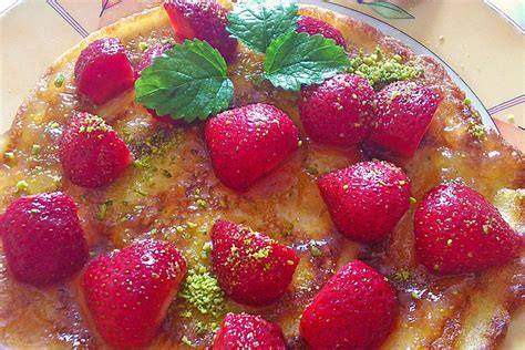 Belegen der Schokotarte mit frischen Erdbeeren und Pistazien