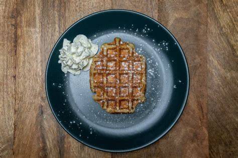Belgische Waffel auf Teller mit Puderzucker und Allergenpiktogrammen