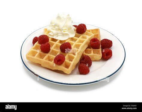 Belgische Waffeln mit Himbeeren und Sahne auf einer kitschigen Tortenplatte