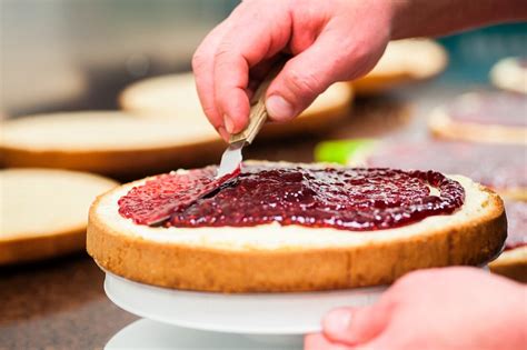 Bestreichen des Biskuitbodens mit Marmelade