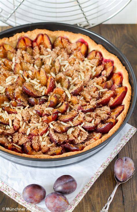 Bienenstich und Zwetschgenkuchen mit Mandeln, angerichtet auf rustikaler Holzplatte
