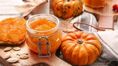 Bild: Gläser mit Kürbis-Orangen-Marmelade auf Herbsttisch