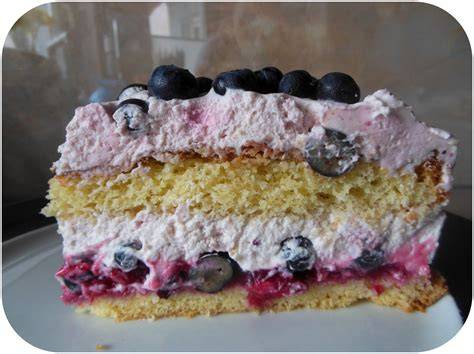 Biskuitboden und fertige Heidelbeer Käse Sahne Torte mit Sahnetuffs und Beeren