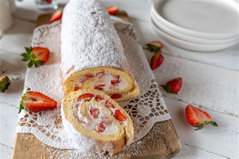 Biskuitrolle mit Erdbeeren und Sahne dekoriert