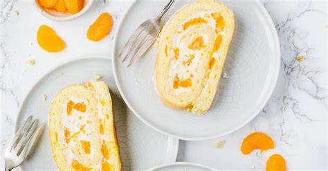 Biskuitrolle mit Mandarinen, angeschnitten und angerichtet