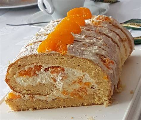 Biskuitrolle mit Mandarinen, angeschnitten und dekoriert