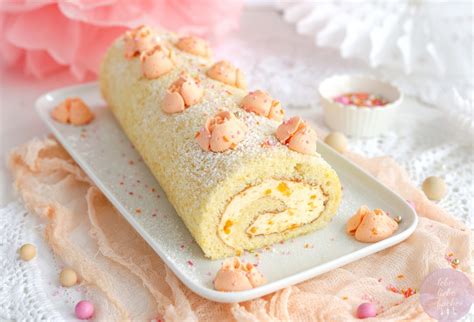 Biskuitrolle mit Tortenspitze und passender Deko auf edler Kuchenplatte