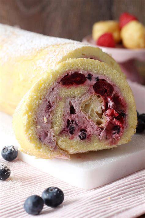 Biskuitrolle vor dem Aufrollen, mit Creme und Obst auf dem Teig verteilt