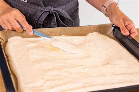Biskuitteig auf dem Backblech vor dem Backen