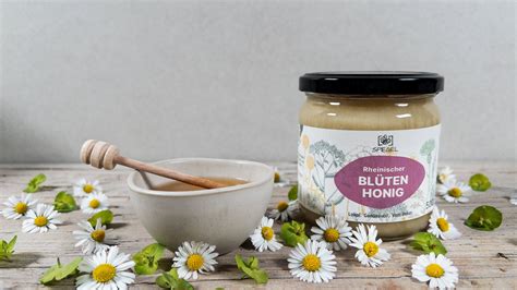 Blütenhonig auf dem Frühstückstisch mit verschiedenen Blüten