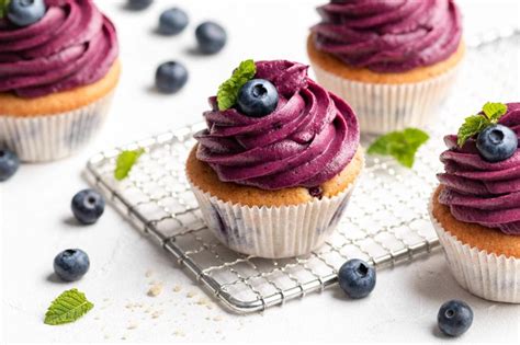 Blaubeer-Cupcakes mit lilafarbenem Frischkäse-Topping und Sterntülle