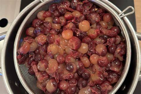 Blaubeer-Glasur im kleinen Topf mit Sieb