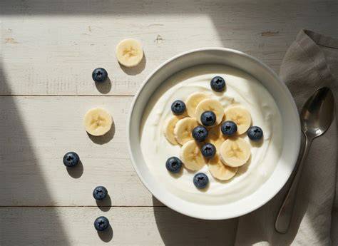 Blaubeerpfannkuchen angerichtet mit Joghurt, frischer Banane und Heidelbeeren