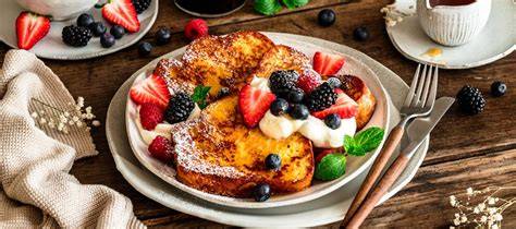 Blaubeerpfannkuchen auf einem rustikalen Frühstückstisch, garniert mit frischen Beeren