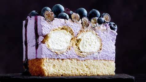 Blaue und rosafarbene Torte mit Beerenmix und Windbeuteln als Querschnitt