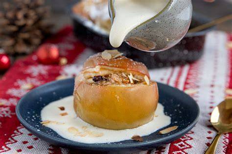 Bratapfel mit Marzipan auf Teller, garniert mit Zimt und Sahne