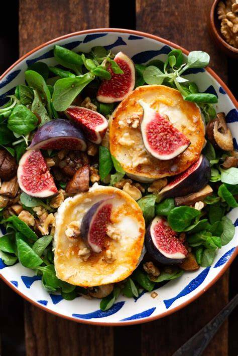 Bratapfel mit Ziegenkäse und Honig, angerichtet auf Feldsalat