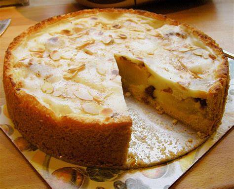 Bratapfelkuchen auf einer festlich gedeckten Tafel mit Marzipan und Zimt