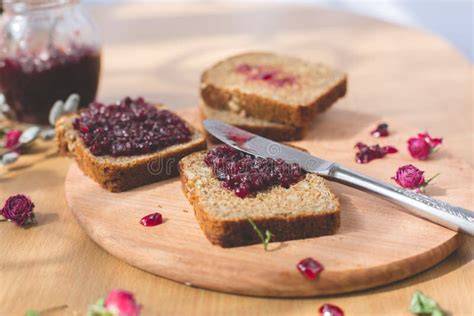 Brot mit Blaubeer-Himbeer-Marmelade frisch bestrichen