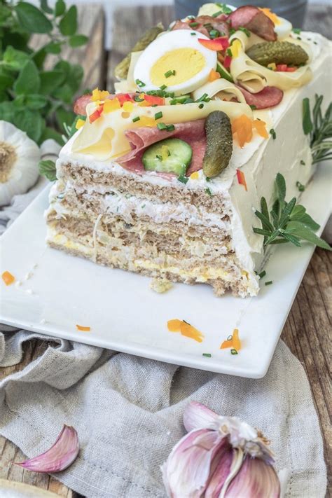 Brottorte im Anschnitt: Mehrere Schichten Mett, Frischkäse und Brot sichtbar