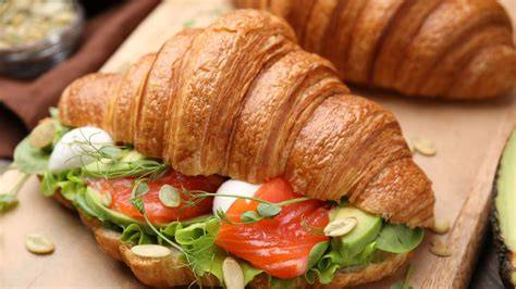 Brunch-Platte: Croissants, Eier, Lachs, Avocado und Marmelade