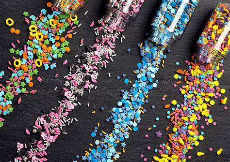 Bunte Ausstechformen und verschiedene Zuckerstreusel auf einem Tisch
