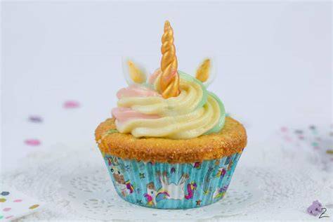 Bunte Einhorn Cupcakes mit Fondant-Ohren und goldenen Hörnern