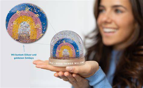 Bunte Schneekugel mit Regenbogen als zentrales Motiv