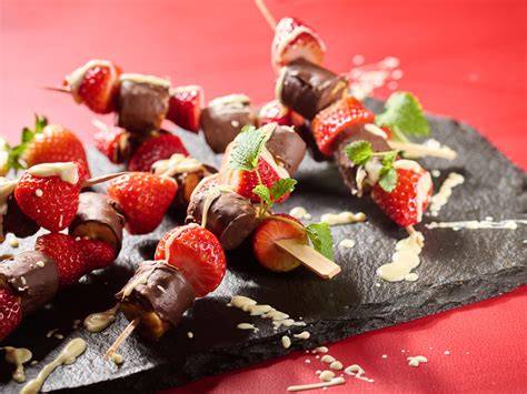Bunte Schokospieße mit Erdbeeren, Bananen und Toppings