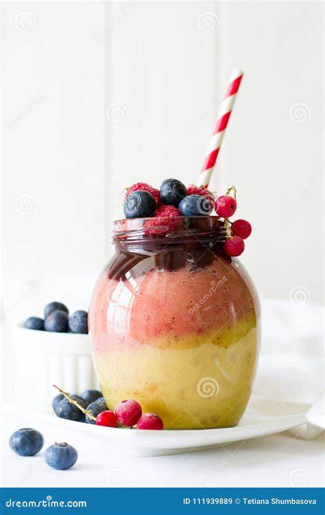 Bunter Birnen-Beeren-Smoothie im Glas mit Strohhalm