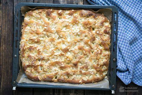 Butterkuchen mit Schokolade auf dem Blech, Detail: Mulden mit Schokobutter und Nuss-Topping