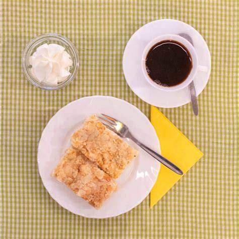 Butterkuchen mit Tasse Kaffee und Sahne