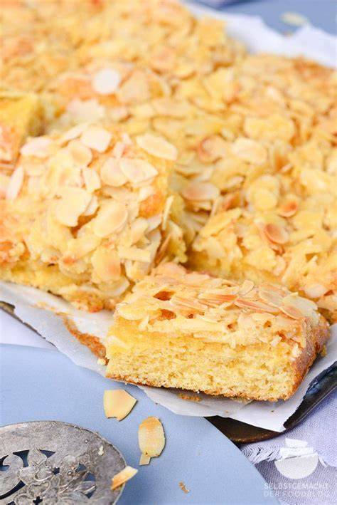 Butterkuchen mit goldbraunen Mandelblättchen und Puddinginseln auf dem Blech
