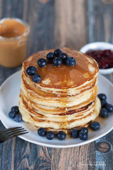 Buttermilch Pancakes auf einem Teller mit Ahornsirup und Beeren