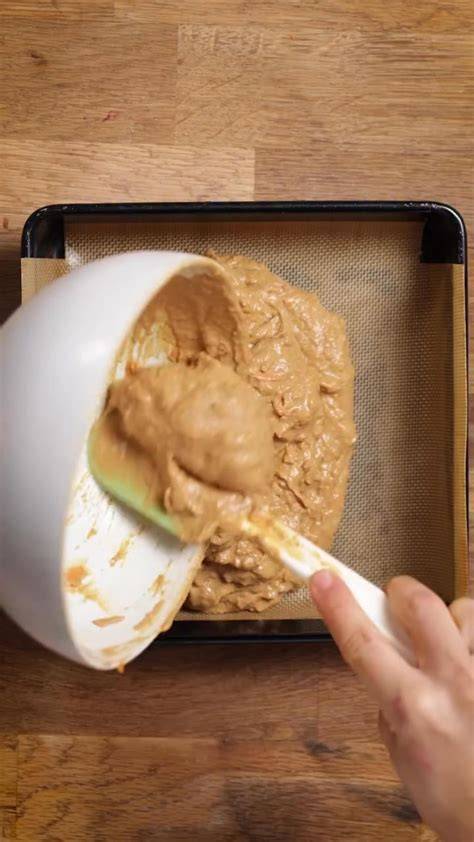 Cashew-Schoko-Aufstrich im Glas, Zutaten (Cashews, Kakao, Kokosöl) und Messer auf Holzbrett