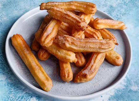 Churros auf einem Markt: goldbraun frittiert und mit Zimt-Zucker bestreut