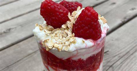 Cranachan im Glas mit gerösteten Haferflocken und Himbeeren