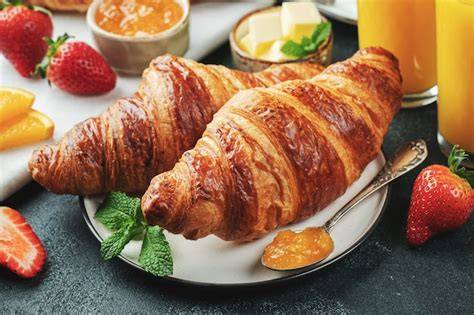 Croissant halbiert mit Butter und Marmelade