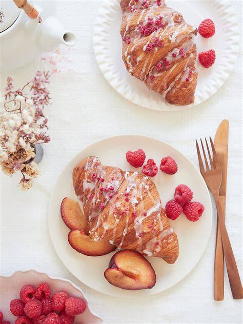 Croissant-Sandwichs auf einem bunten Frühstückstisch
