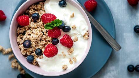 Croissants mit Joghurt und Müsli auf Camping-Tisch angerichtet