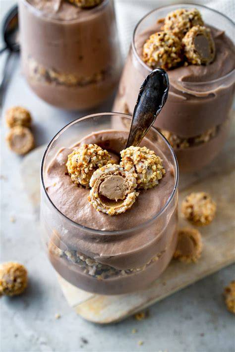 Darstellung einer Tahin-Kakao-Creme im Glas, zusammen mit Kakaobohnen und Sesam