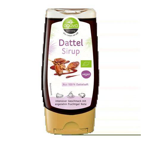 Dattelsirup in Glasflasche mit getrockneten Datteln und Holzlöffel