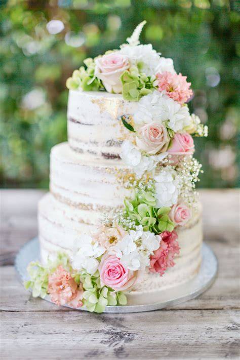 Dekor und Präsentation einer Hochzeitstorte: Blumen, Früchte, Drip-Effekt