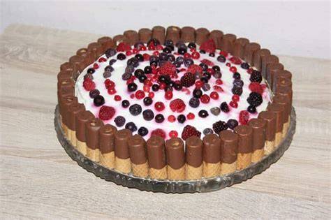 Dekoration: Kakao, Haselnusskrokant, Waffelröllchen auf Nougat-Torte