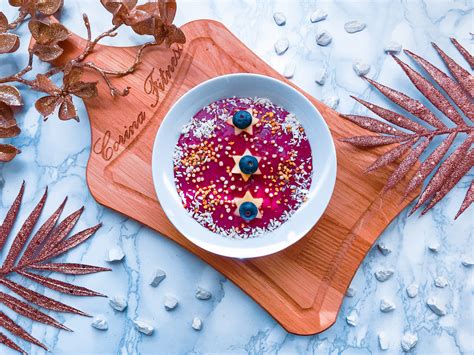 Dekoration: Kiwi-Ringe, Kokosflocken und Beeren auf glänzendem Spiegel