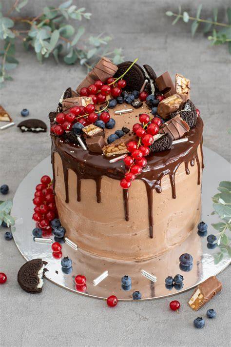 Dekorationsideen: Beeren, Macarons, Schokoriegel auf Drip Cake