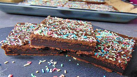 Dekorationsideen: weißer Guss, dunkle Kuvertüre und bunte Streusel auf Blechkuchen