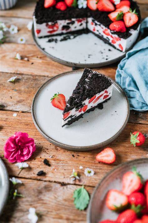 Dekorative Nahaufnahme: Erdbeer Joghurt No Bake Torte mit Oreos und Sommerblumen