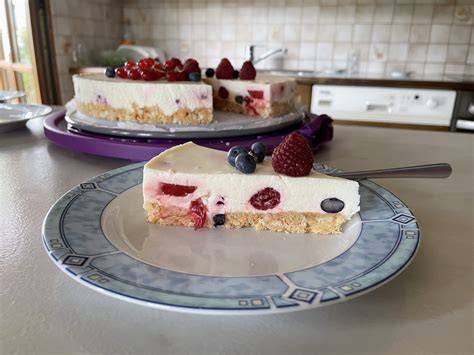 Dekorierte Frischkäsetorte mit Rosetten und Beeren