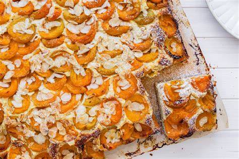 Dekorierte Kürbis-Motive aus Aprikosen und Schokolinsen auf dem Blechkuchen